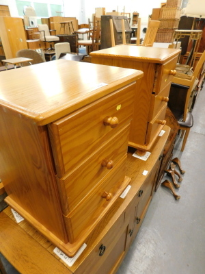 A pair of pine effect three drawer bedside chests.