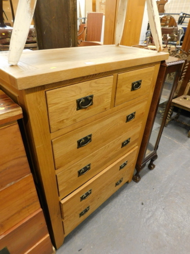 An oak chest of two short and four long drawers, each with brass handles.