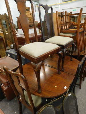 A walnut extending dining table and four various Queen Anne style chairs.