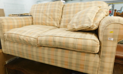 A two seat sofa bed, upholstered in chequered fabric.