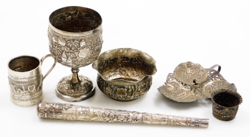 A collection of Oriental silver coloured metalware pieces, to include a goblet with embossed and repousse decoration of buildings, figures, etc., a similar bowl, small mug with a hunting scene, stamped T90, parasol handle, and trefoil dish, etc. (6)