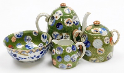 A Japanese Meiji period porcelain part tea set, decorated with multicolour roundels on a green ground with gilt karakusa scrolls, Fukugawa mark beneath Mount Fuji to underside, the teapot 15cm high.