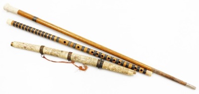 A Japanese Meiji period short sword (tanto), the bone handle and scabbard carved with figures (AF), 54cm long, a walking stick, probably Indian, with carved bone handle and a Japanese bamboo flute. (3)