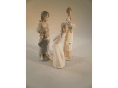 A Lladro figure group of a girl cradling a kid