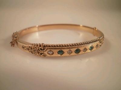 A Victorian hinged bangle set with tiny emeralds and diamonds