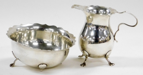 An Edward VII silver cream jug, with a shaped ring and handle, raised on four paw feet, Birmingham 1902, 3½oz, 8.5cm high, and a matching sugar bowl, 3½oz. (sugar bowl AF)