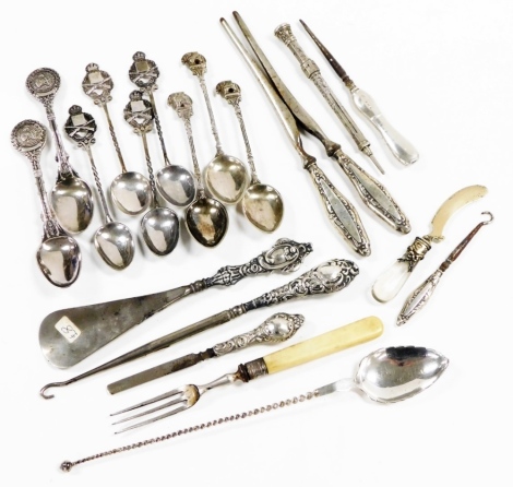 A group of white metal and silver mounted items, to include a shoe horn, white metal tea spoons with shaped elephant handle, silver handled button hook with repousse decoration, etc. (a quantity)