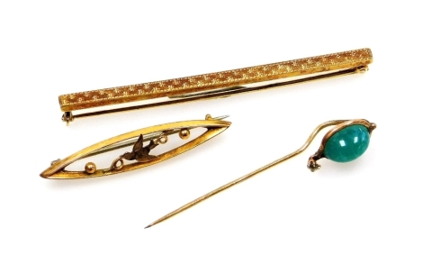 Two brooches and a stick pin, comprising an Edwardian 9ct gold oval bar, with pierced central swallow motif, 4cm wide, a jade cz and yellow metal stick pin, 5cm high, and an engine turned engraved bar brooch of plain design, 6cm wide, unmarked possibly si