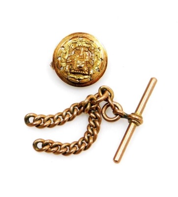 Two items of jewellery, comprising a Middle Eastern inspired pendant/brooch, with raised relief central Aztec type figure on a circular bar with a pendant loop and pin back, yellow metal stamped 18k, 2cm wide, together with a 9ct gold part watch chain and