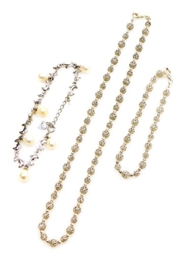 A group of filigree jewellery, comprising a ball design necklace and bracelet, each stamped 925, 42cm and 16cm long, together with an 18ct white gold plated dolphin bracelet, the silver 21.1g. (3)