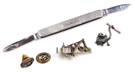 A group of Ruston-Bucyrus jewellery and vertu, comprising a penknife, Swank tie clip, silver tie pin, and a pair of 9ct gold pins for 25 years service, one lacking back, the gold pins 13g all in.