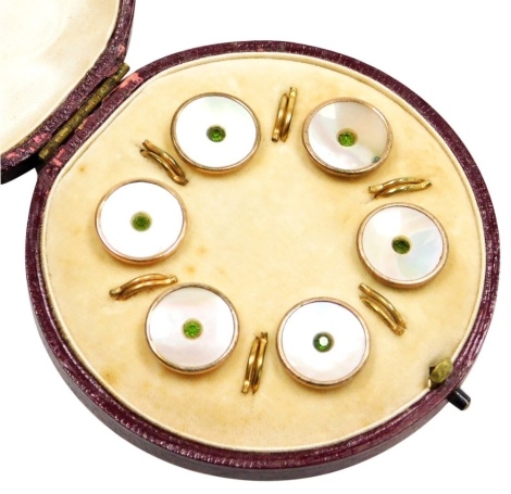 A cased set of rose gold collar studs, each with mother of pearl decoration and central green paste stone, in a yellow metal setting unmarked, in fitted case.