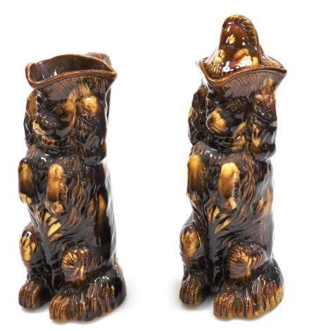 A pair of 19thC Staffordshire treacle glazed poodle jugs, in standing poses, one with lid, 30cm high overall.