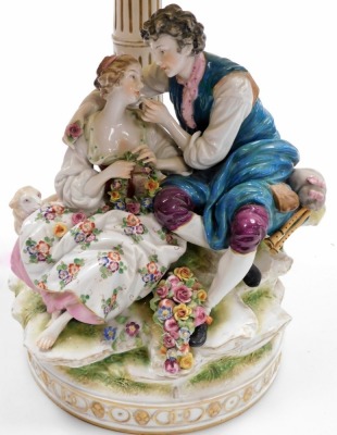 An early 20thC Continental porcelain figure group, modelled as a pair of lovers seated by a column, with a lamb and basket of flowers, now converted to a table lamp, 30cm high. (AF) - 2