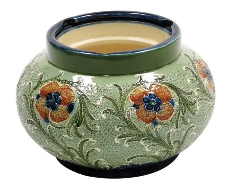 A Moorcroft Macintyre and Co Florian ware pottery tobacco jar, decorated with flowers against a textured green ground, lacking lid, 13cm diameter.