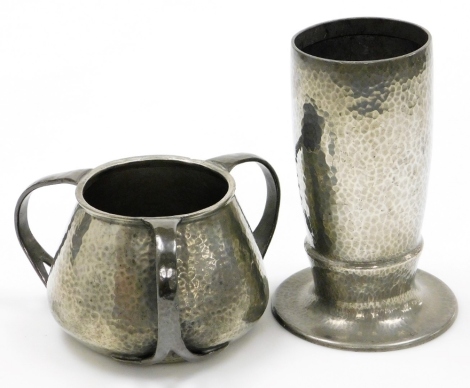 A Solkets pewter Arts and Crafts hammered vase, on circular foot, 27cm high, and a tyg with hammered body, numbered 01064, 18.5cm wide. (2)