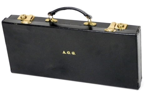 A black leather case, with brass catches and locks, initials A.G.G., 46cm x 20cm.