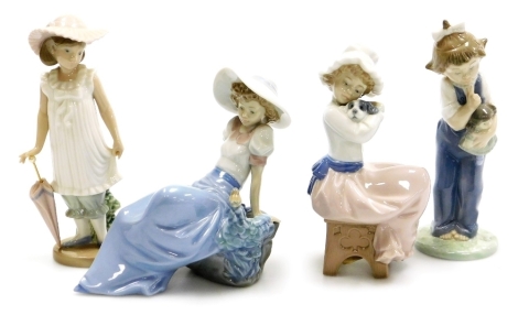 Four Nao porcelain figures, comprising girl with umbrella, 19cm high, girl reposing on rock, 15cm high, girl with doll, 18cm high and girl seated with dog, 18cm high, each boxed.