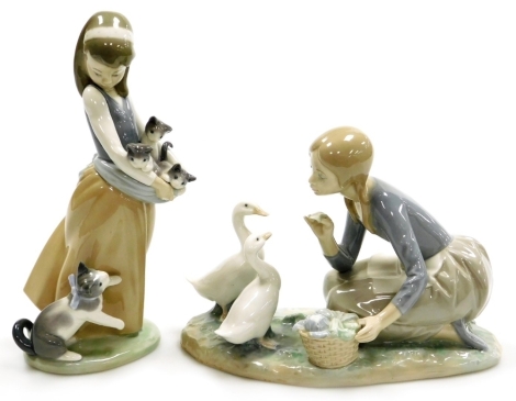 Two Lladro porcelain figure groups, comprising girl kneeling feeding geese, 17cm high, and girl holding kittens, 24cm high.