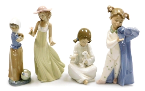 Four Nao porcelain figures, comprising girl feeding lamb, 17cm high, girl holding puppy, 22cm high, girl putting on overcoat, 25cm high, and lady holding flower, 27cm high, all boxed.