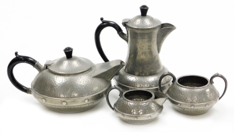 A Craftsman Sheffield hammered pewter Arts & Crafts style four piece tea service, comprising teapot, hot water jug, two handed sugar bowl and milk jug.