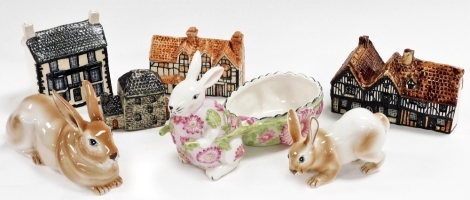 Two Villeroy and Boch porcelain rabbits, 16cm and 11cm wide, a Villeroy and Boch porcelain rabbit, 19cm high, and four John Putnam's Heritage Houses pottery houses. (a quantity)