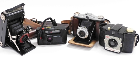 A group of cameras, comprising a Cornell camera in leather case, a Kodak Brownie Cresta camera, a Netter camera and a Pentax PC34AF.