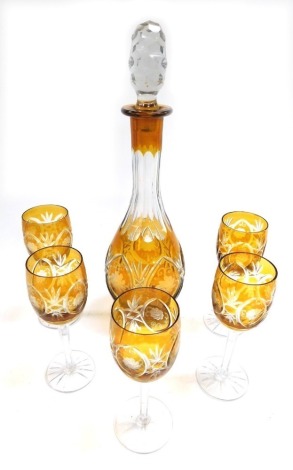 A Bohemian amber flash glass decanter and stopper, floral engraved, together with five stemmed wine glasses. (6)