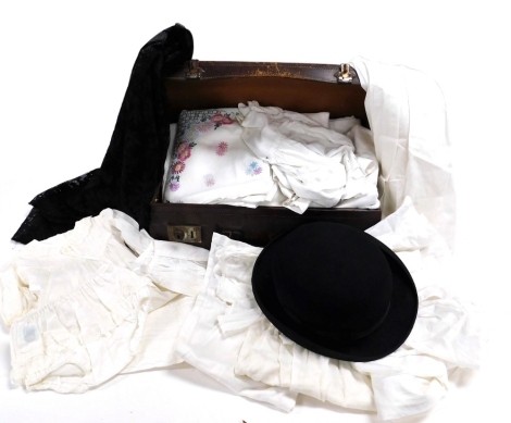 Victorian and later linen and lace, a black lace mantilla, christening robes, mid 20thC children's clothes, in a brown leather case, together with a Woodrow Amylyte bowler hat size 7&#8539?.