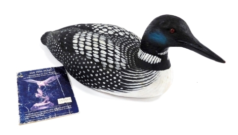 A Ma Hai Feng carved wooden figure of a Loon bird, with painted detailing, with booklet about the artist, 34cm wide.