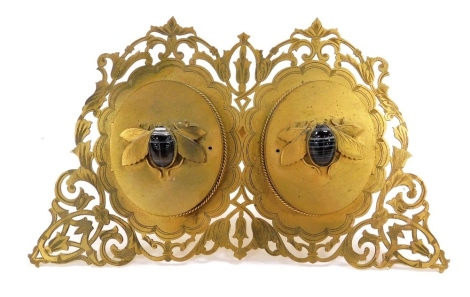 A Victorian brass strut double photograph frame, by Howell James and Company, Regent Street London, pierced and engraved floral and foliate form, with two central oval frames, having hinged lids surmounted by hard stone set scarab beetles, impressed marks