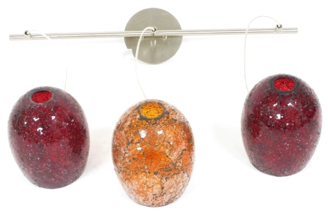 A three branch ceiling light, with crackled red and orange glass pendant shades, 72cm wide.