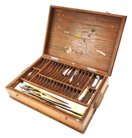 An early 20thC artist's paint box, with tray inset, containing paints, brushes, pallets, etc., 41cm wide, 28cm deep.