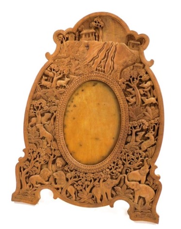 An early 20thC Anglo Indian wooden strut photograph frame, carved in bass-relief with wild animals and a jungle landscape, 34cm high, 26.5cm wide.