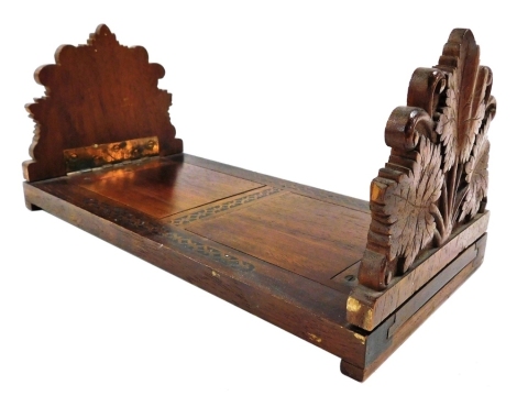 A late 19thC Tyrrolean hardwood book slide, with leaf carved ends, 30.5cm wide.