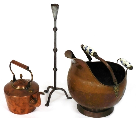 A copper helmet shaped coal scuttle, together with a copper kettle and a wrought iron rush light.