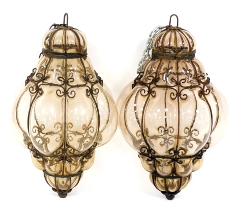 A pair of Continental wrought iron and lobed glass hanging lanterns, 40cm high.