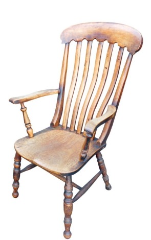 A Victorian oak and elm lath back kitchen chair, with solid saddle seat, raised on turned legs united by a H frame stretcher.