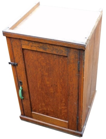 An early 20thC oak cupboard, with a single door opening to reveal a shelf with drawer under, raised on a plinth base, 82.5cm high, 39.5cm wide, 38cm deep.