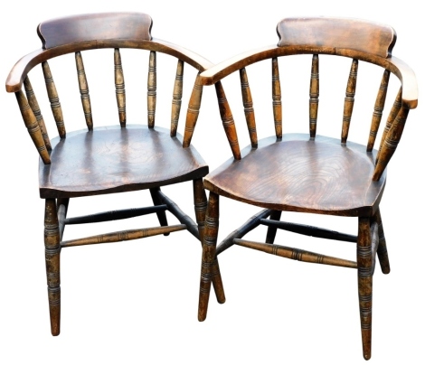 A pair of Victorian beech and elm Captain's type tub chairs, with solid saddle seats, raised on turned legs united by a double H frame stretcher.