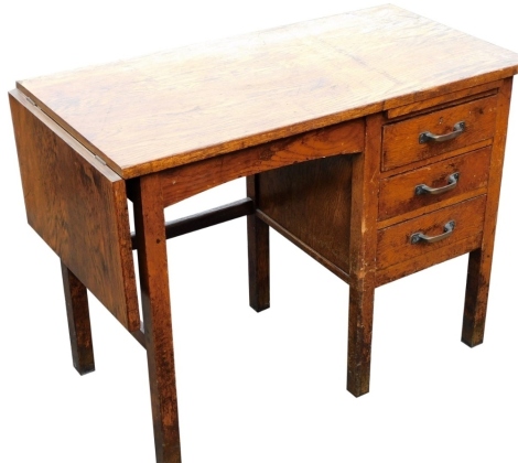 An early 20thC Bell-Barn oak desk, with a drop flap and three single pedestal drawers, raised on square style legs, 72cm high, 95.5cm wide, 124.5cm extended, 48.5cm deep.