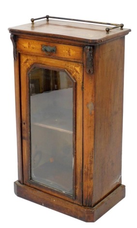 A Victorian walnut and inlaid cabinet, inlaid with vases and scrolling leaves, having a single drawer above a glazed door enclosing a single shelf, raised on a plinth base, 92cm high, 51.5cm wide, 33cm deep.