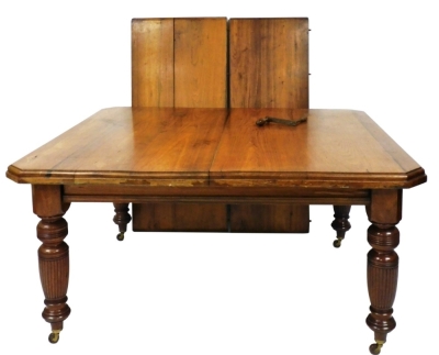 A Victorian mahogany wind out dining table, with two additional leaves, raised on turned and fluted legs, brass capped on castors, 22cm high, 140cm wide, 238cm extended, 121cm deep.