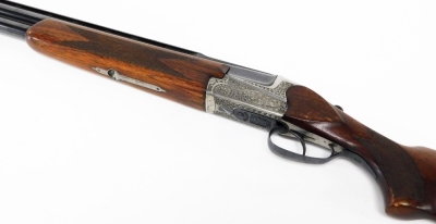 An over and under 12 bore shotgun, with ejector, by Simson Suhl (DR), engraved with a gun dog and hare and scrolling ornamentation, barrels 71cm NB. A current valid Registered Firearms Dealer Certificate will be required to view and bid for this lot. Fo - 2