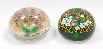 A Perthshire floral paperweight, decorated with trailing flowers on a trellis, green ground, underside dated cane for 1992, 8.5cm diameter, and a further paperweight, decorated with pink millefiori flowers, green stems and leaves against a gold aventurine - 3