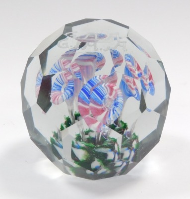 An early 20thC faceted glass paperweight, decorated internally with four glass stemmed flowers, on a green base, beneath initials 'G. A. A.', 9.5cm diameter. - 3