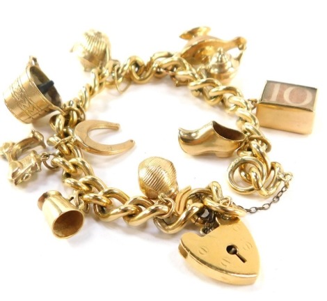 A charm bracelet, with ten 9ct gold charms on a rolled gold curb link bracelet, with heart shaped padlock and safety chain, 20cm long.