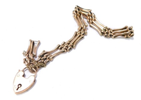 A 9ct rose gold gate bracelet, of three bar design, with safety chain and padlock, 11.1g, 20cm long. (AF)