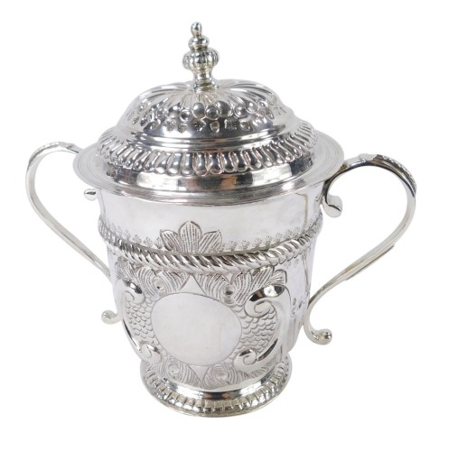 A George V Britannia silver copy of a seventeenth century porringer, of twin handled, covered form, with fluted and engraved decoration, oval vacant reserve, engraved No 131, Harry Freeman, London 1913, 12½oz, 17cm high.