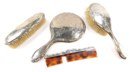 A George V silver dressing table set, comprising a hand mirror, a hair brush, clothes brush and comb, each with Neo Classical engraved decoration, Birmingham 1917. (4)